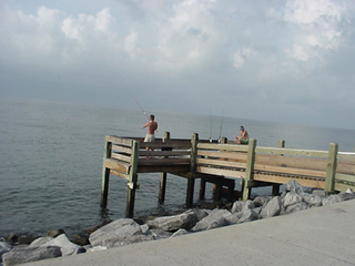A couple of guys fishing on a pier. Pier fishing is very big in this part of the country. This is a relatively wimpy pier.