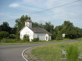 A church in rural Mississippi, closed with Kudzu seeping out the doors