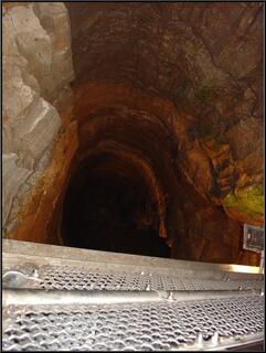 Looking down into a vertical shaft, created by water flowing down from ground level to water level