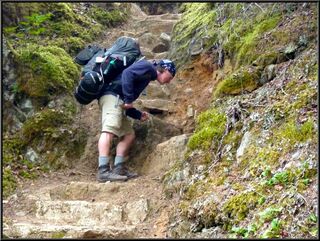 Simulated action shot. Looks like he's shoveling more than hiking