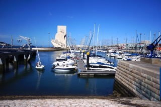 A small boat harbor, with Padrao dos Descobrimentos in the distance...