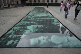 GDR reality just below the mural, protesting masses in a photograph from 1953