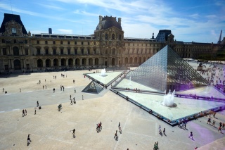 Looking out at the courtyard, the Denon wing dappled in pyramid reflection