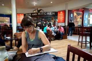 Theresa journaling at Pub and Kitchen before the long flight home
