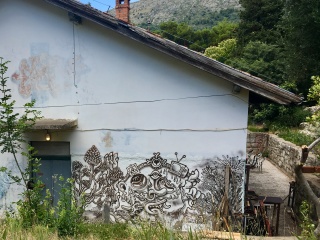 Somebody drew a whole world on the side of a shed.