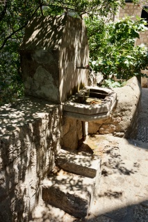 An old wall fountain in the shade. The back way pays its way.