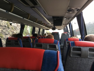 On the coach, cliffs sliding by.