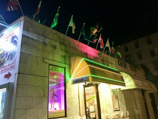 Flags and neon. Window shopping by night.