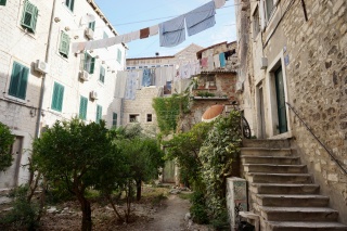 Laundry strung over the courtyard, stairs up the side.