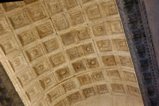 The coffered vault overhead, every square carved.