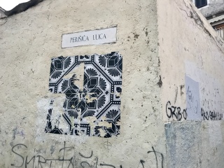 An old tile set into the wall, name plate above it.